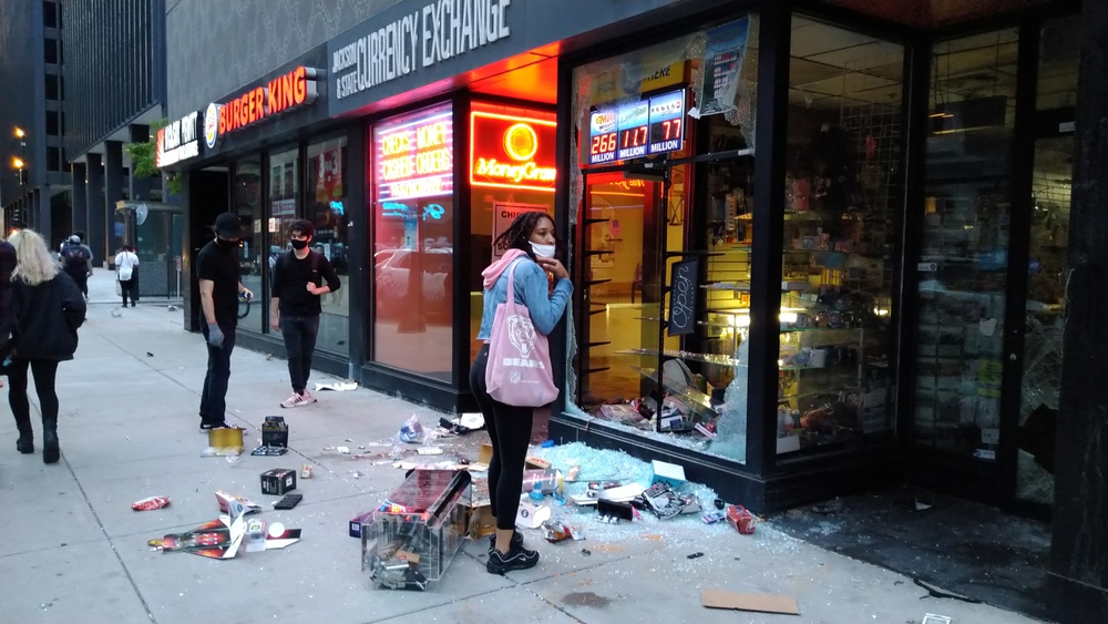 People in front of vandalized storefronts. Chicago. May 30 2020.