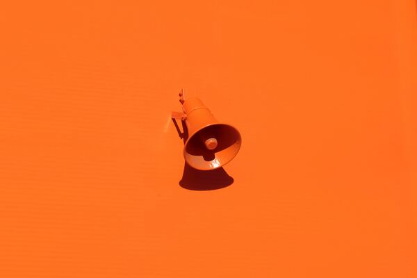 Orange megaphone on orange wall by Oleg Laptev