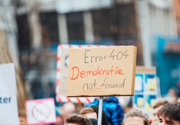 Protester holding sign saying 'Error 404 Demokratie not found'