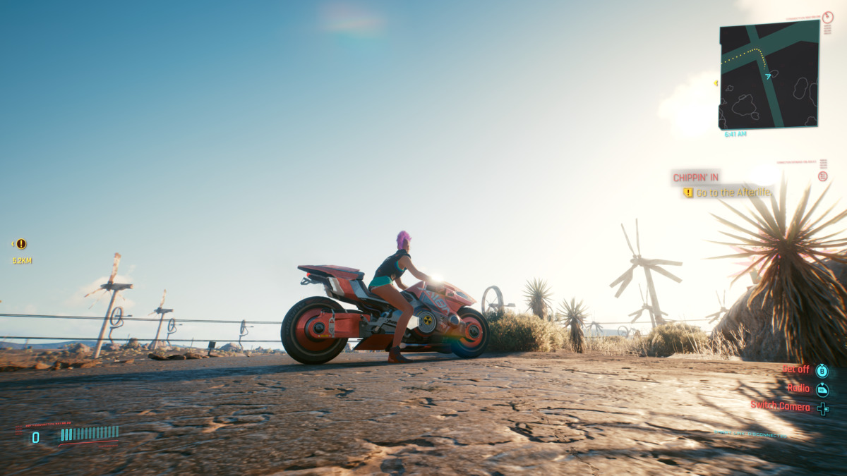 V on a Motorcycle Outside the City Near a Wind Farm