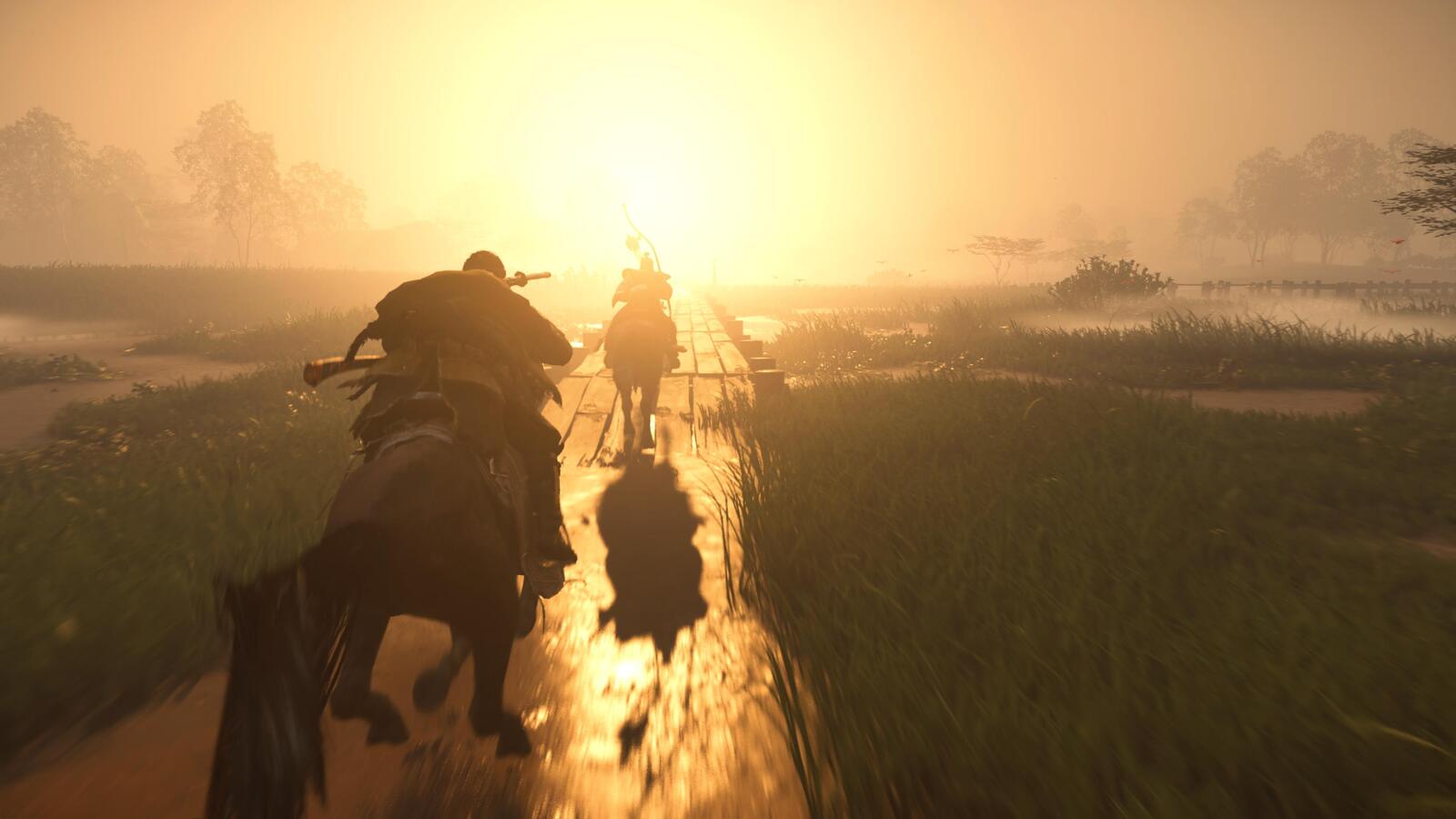 Two people riding on horses into the sunset