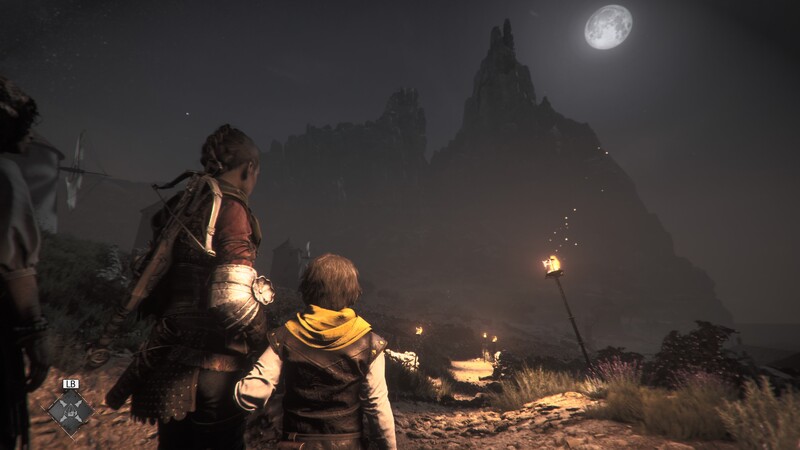 Amicia and her brother Hugo at night with a mountain in the distance