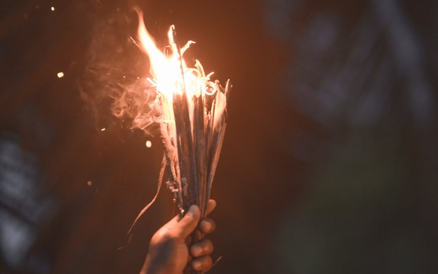 hand holding burning torch