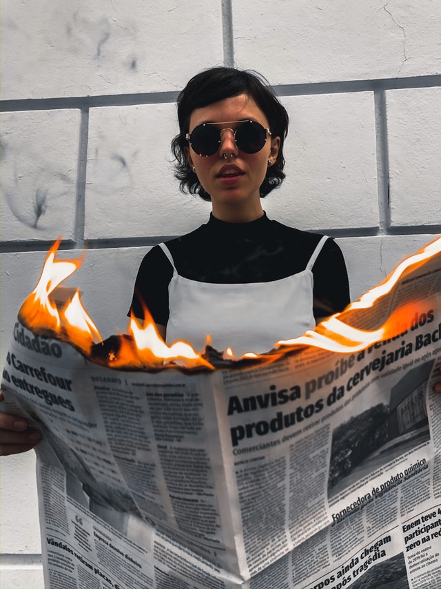 Woman reading a burning newspaper