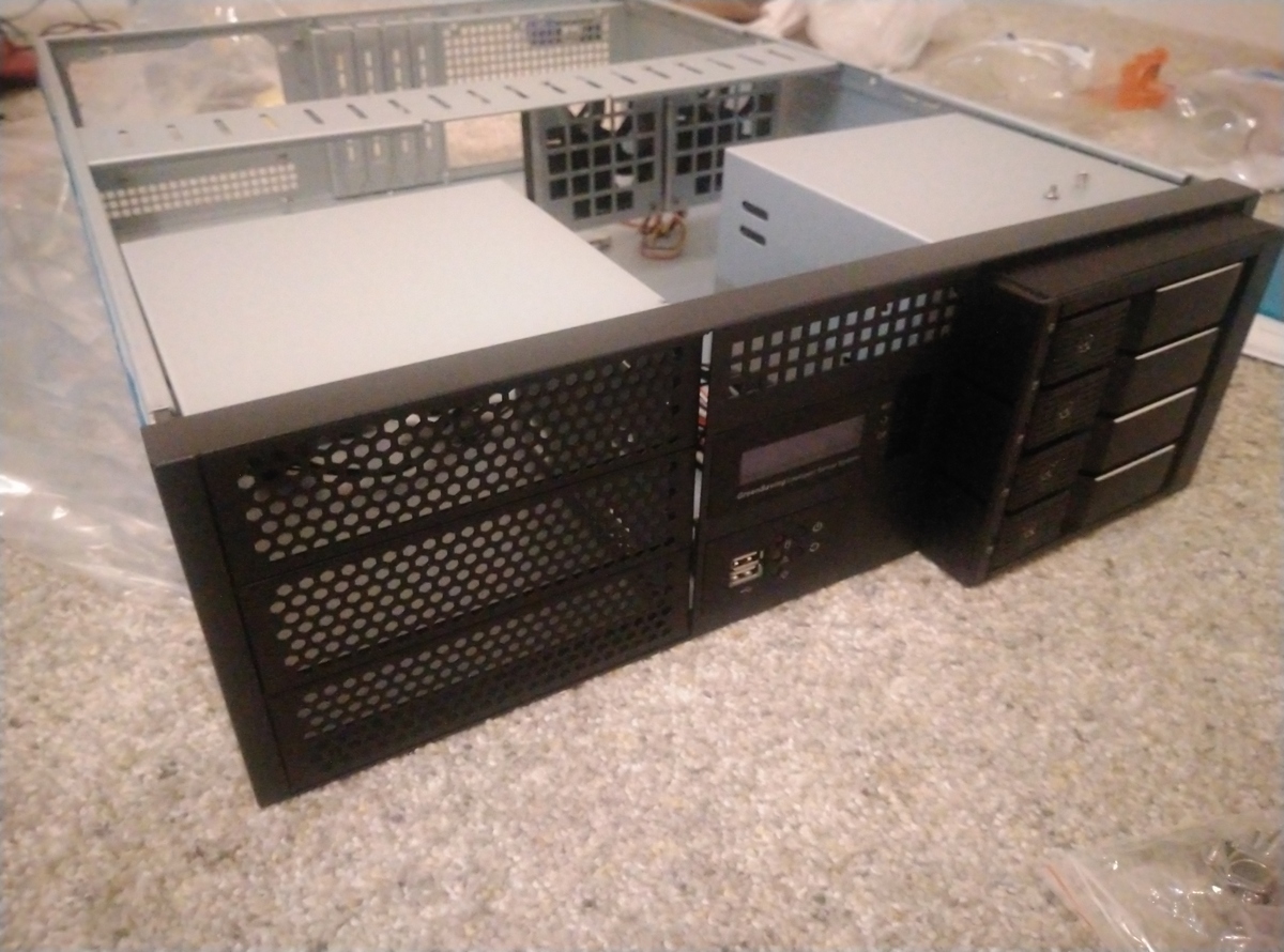 Server case on carpet being fitted with hot-swap drive cage