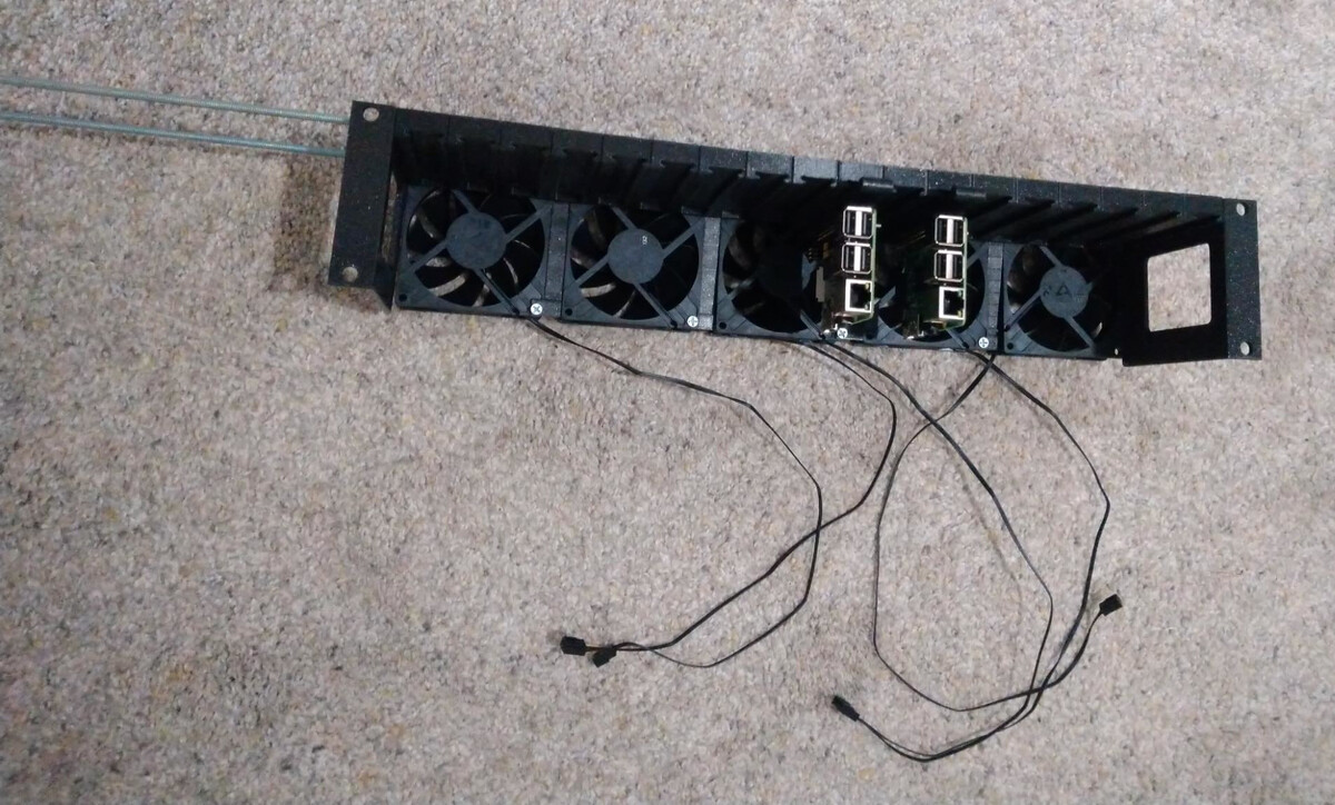 Two Pis installed in completely rack lying on carpet, with the excess length of the threaded rods still present.