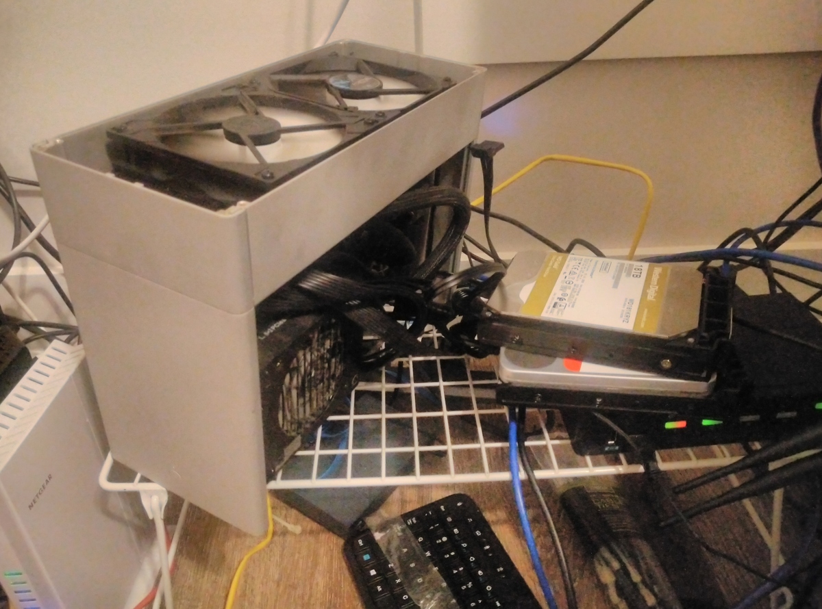 Hard Drives sitting precariously on a KVM switch next to an open ITX case